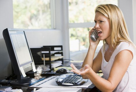 Woman in home office, upset while talking on phone